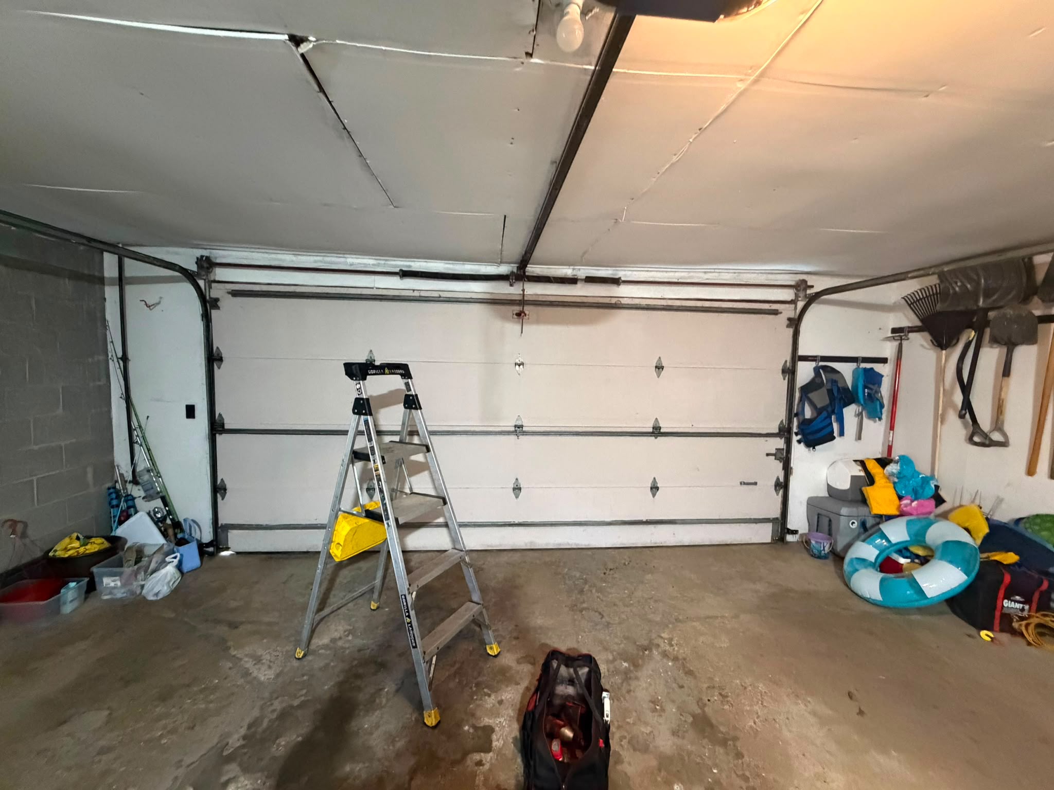 Garage door repair in progress inside a residential garage